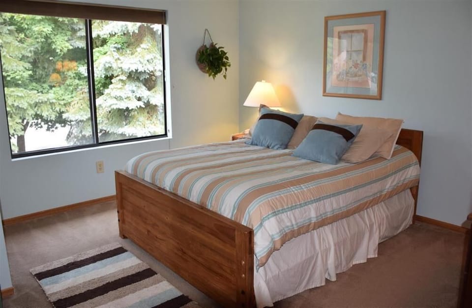 Peaceful bedroom retreat framed by forest views, offering a restful escape wrapped in soft light and calm simplicity.