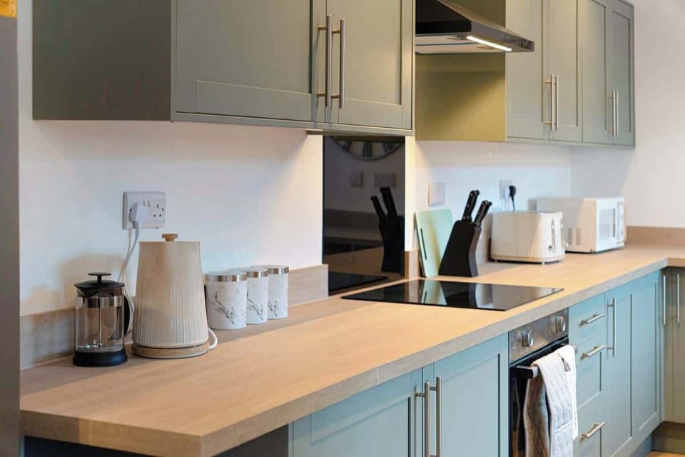 Kitchen equipped with all essentials, including a dryer, oven, fridge and full cookware set.