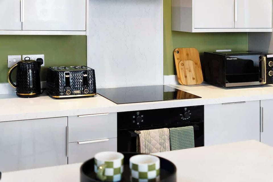 Fully equipped for convenience, the kitchen features an oven, fridge, and a comprehensive cookware set for everyday cooking needs.
