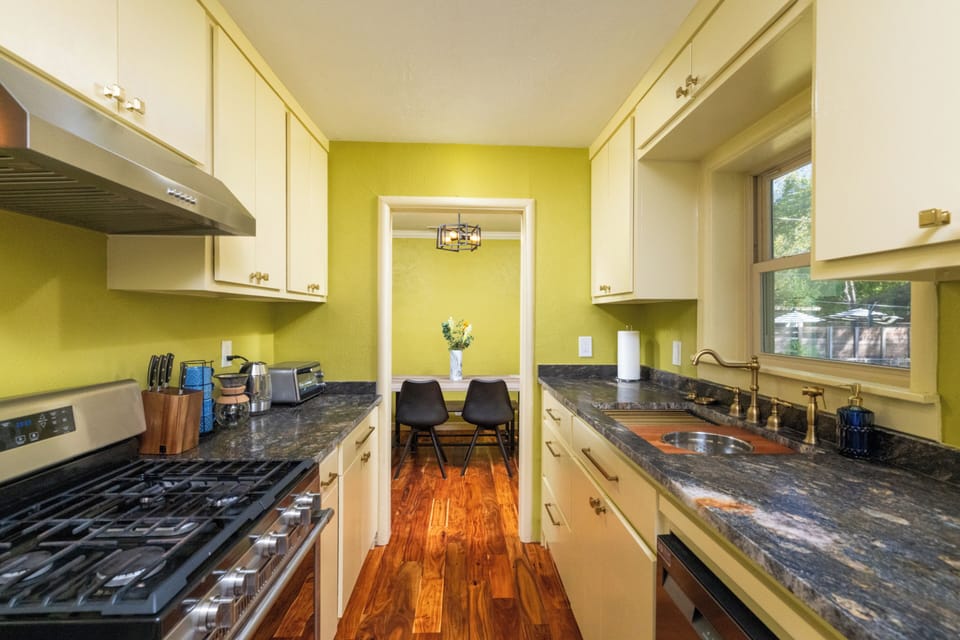 Bright, fully equipped kitchen w/ stainless steel appliances & warm wood floors