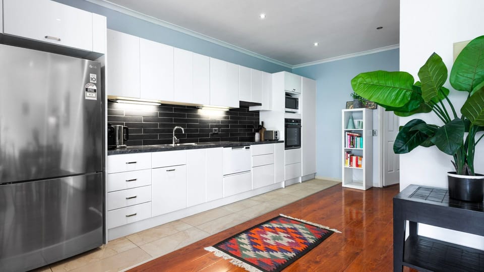 Another angle of the modern kitchen, featuring ample storage and stylish countertops.