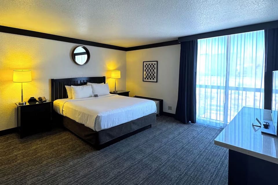 Wake up refreshed in a bright king bed by balcony.