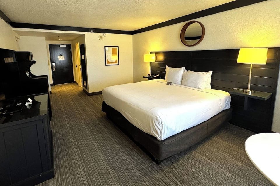 Sink into a plush king bed under warm lighting.
