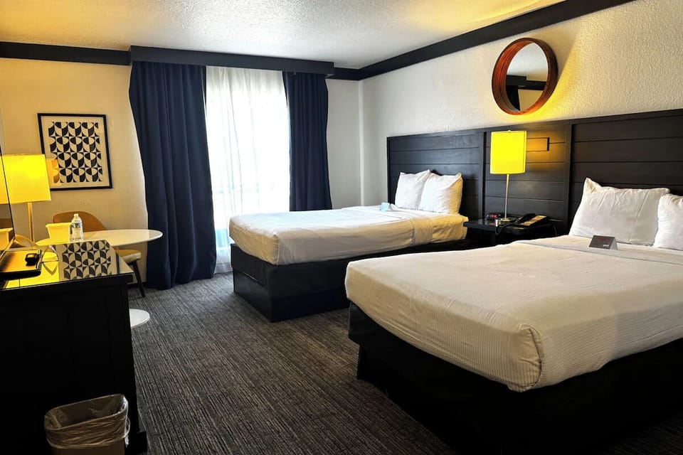 Settle in with warm lamplight, two beds, and a table.