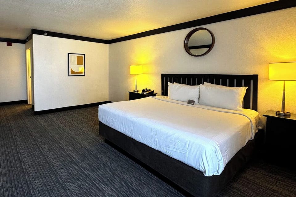 Drift off in a calm king bed under warm bedside glow.