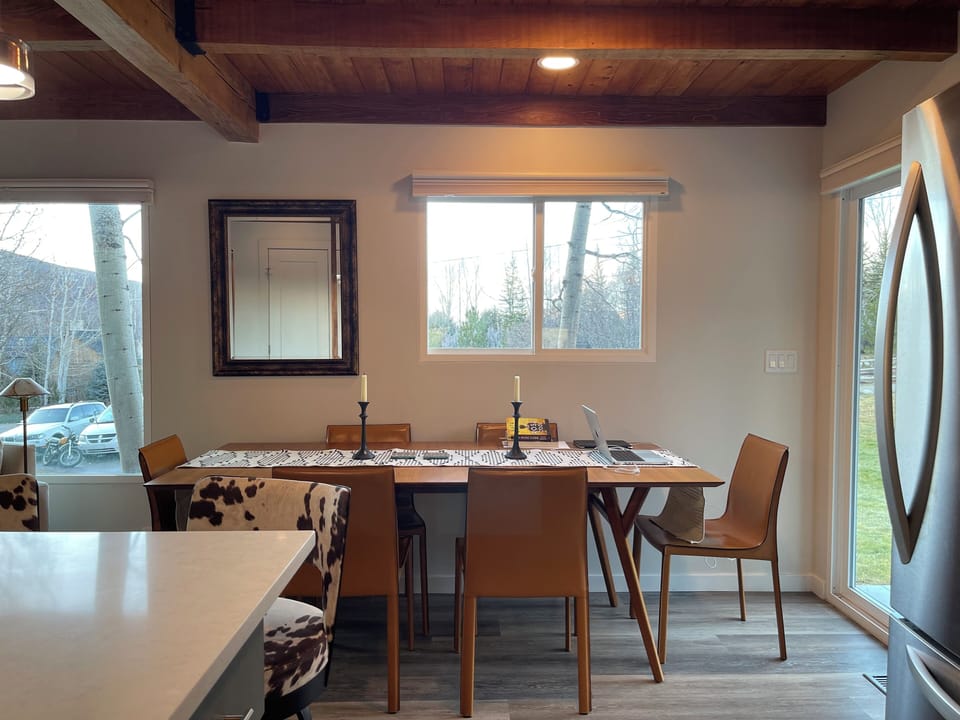 Wood-beamed dining area with natural light and easy access to kitchen