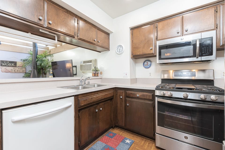 The kitchen offers a complete assortment of dishes, utensils, glassware, bakeware, cookware, and essential appliances
                