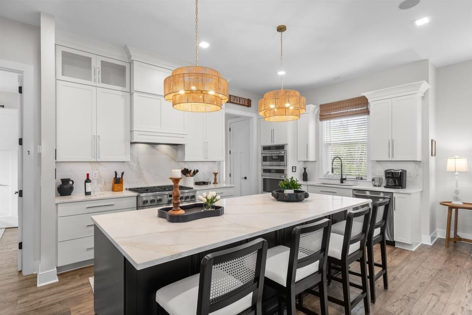 The stunning chef's kitchen features premium stainless steel appliances, quartz countertops, a gas range, double wall ovens, and a spacious island with seating for 4. Fully stocked and designed for effortless entertaining, it's the heart of the home.