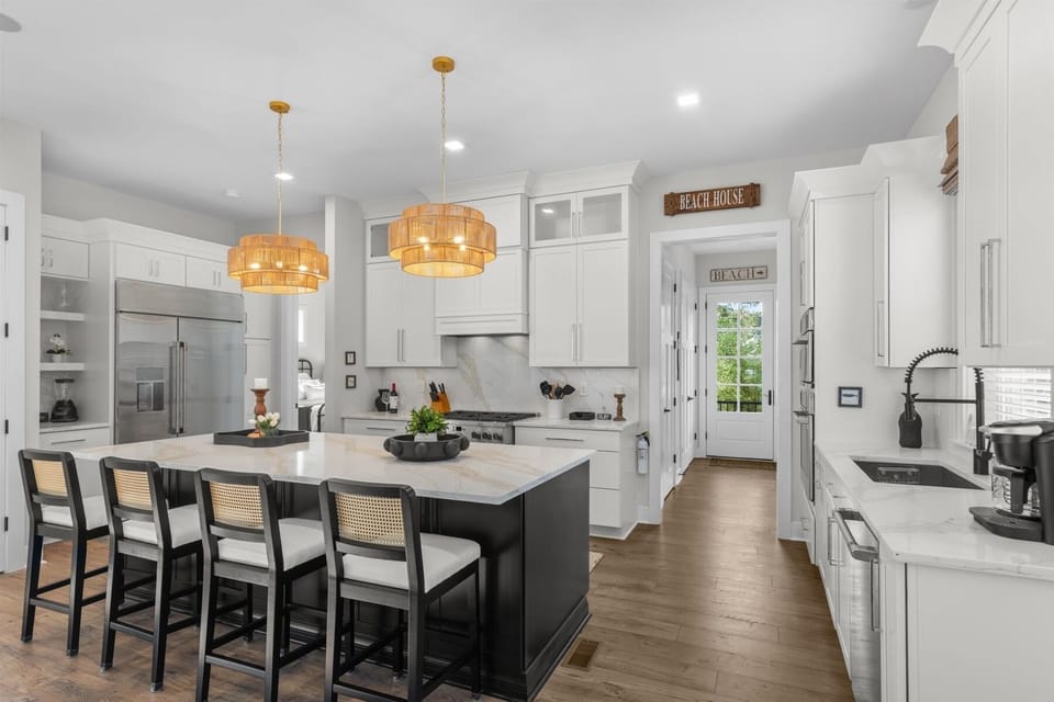 he chef's kitchen is designed for entertaining with high-end appliances, quartz countertops, a large center island with seating for 4, and ample prep space. Fully stocked for everything from quick breakfasts to memorable family dinners.
