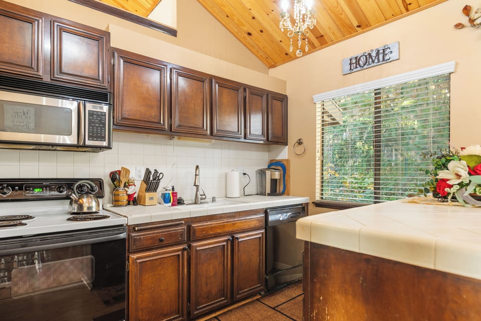 Fully equipped kitchen with wooden cabinetry and modern appliances.