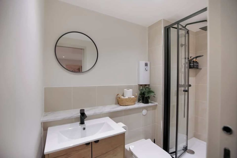 Sink, round mirror and shower