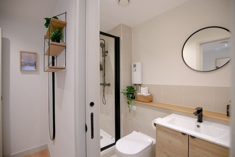 Full bathroom with shower and round mirror