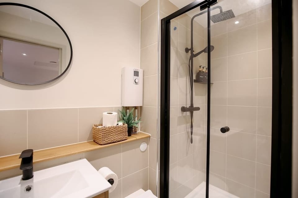 Round mirror, sink, and shower