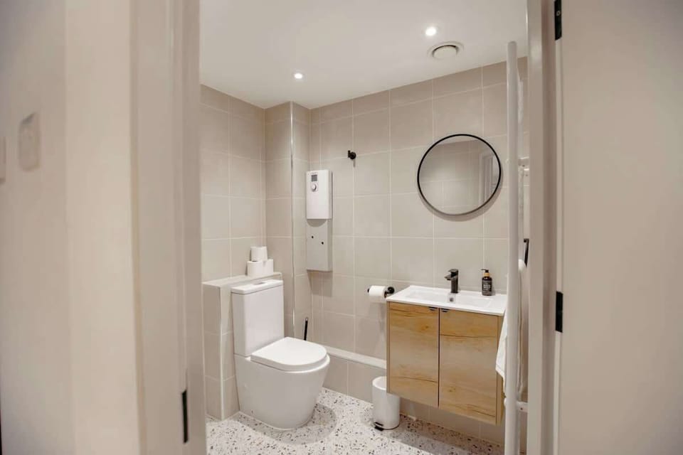 Full bathroom with a round mirror