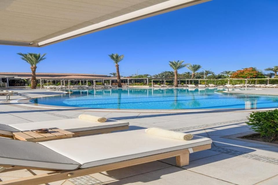 Lounge in the shade while the pool glitters ahead.