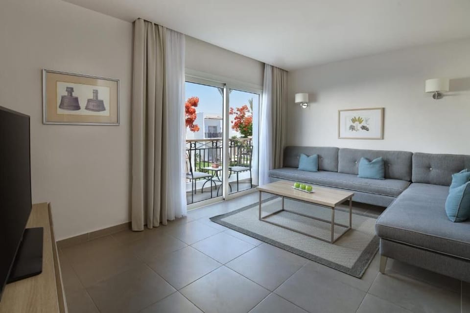 Relax on the spacious sofa beside bright balcony doors.