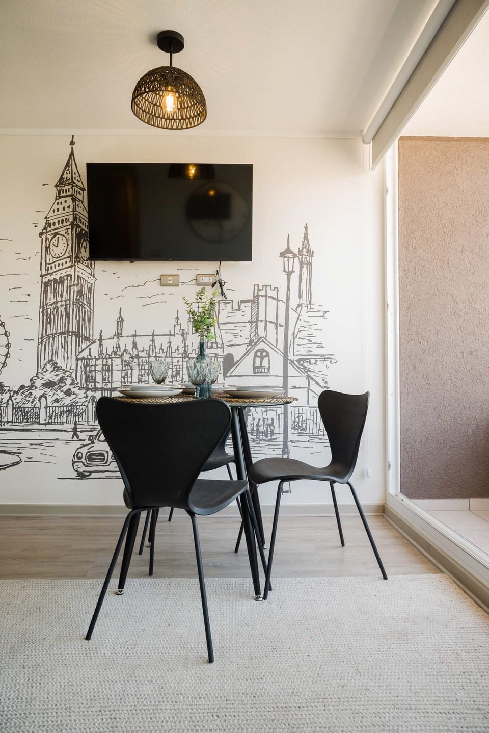 Charming dining area with London-themed decor and cozy seating for four, perfect for intimate meals.