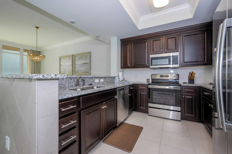 Prepare meals in this elegant kitchen with stainless appliances and stylish speckled stone countertops