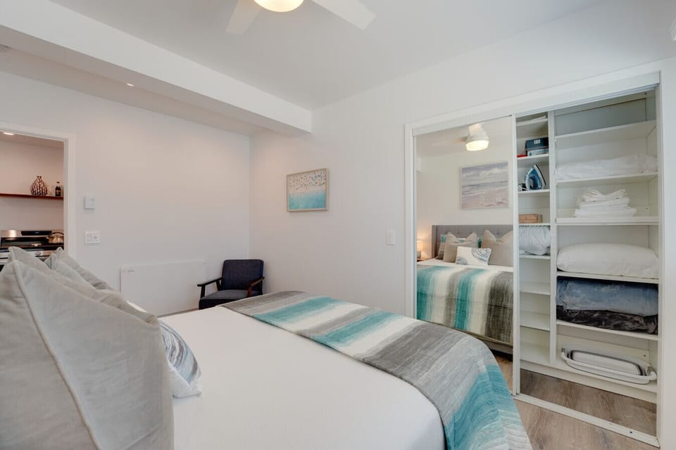 The bedroom has a queen bed, desk, Smart TV, and mirrored closet.