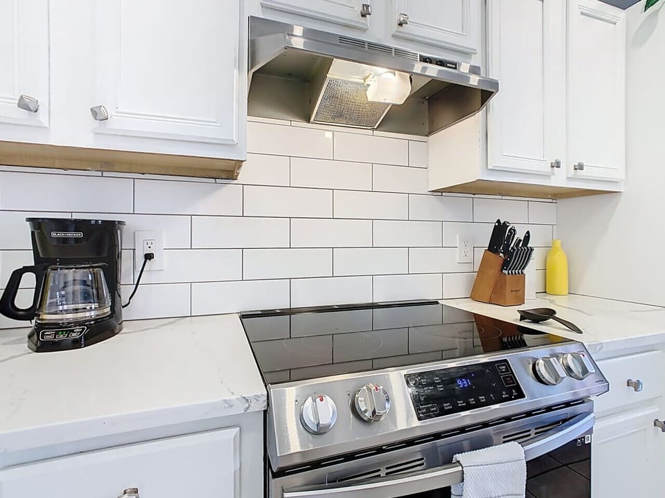 Modern cooking space with stainless steel range and stylish subway tile backsplash.