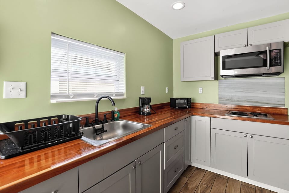 Modern kitchenette with wood countertops and stainless appliances.