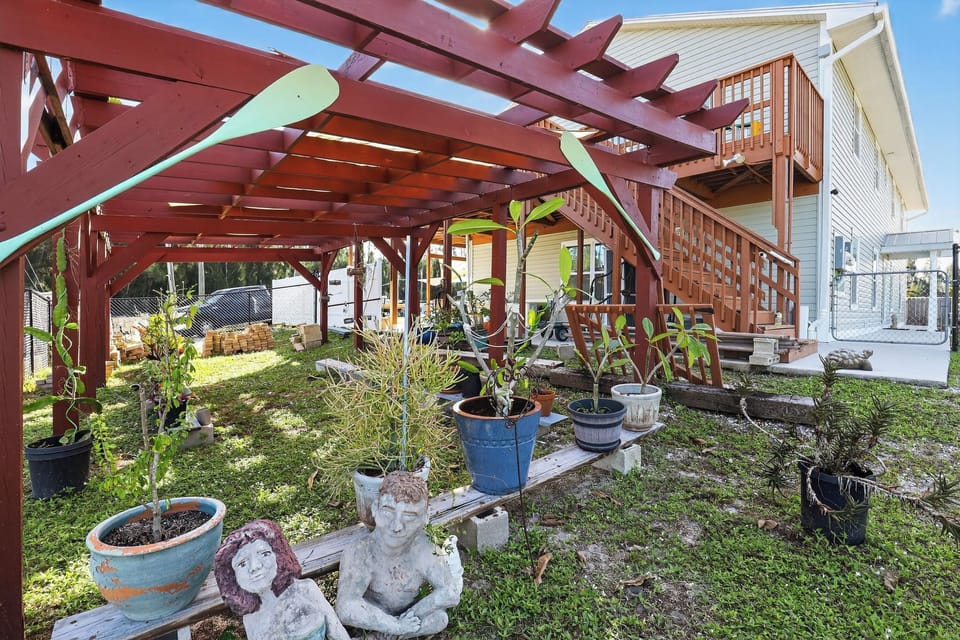 Enjoy the unique garden area complete with plants, sculptures, and a pergola.
