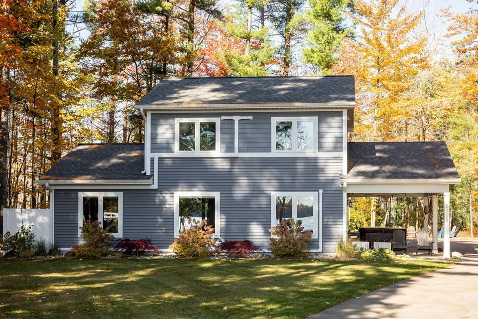 This spacious two-story home features a covered carport with hot tub, landscaped gardens, and a peaceful wooded setting perfect for fall getaways