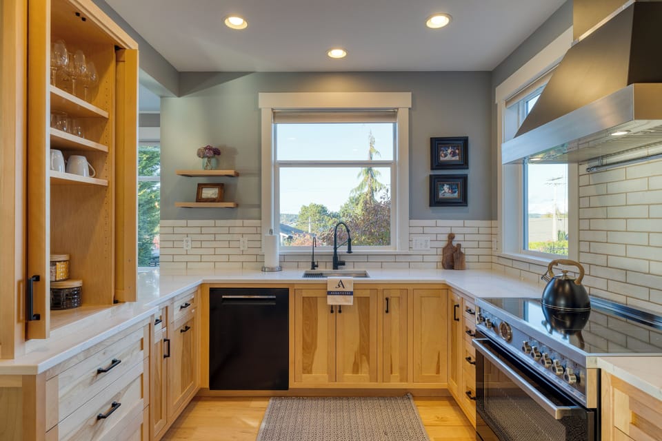 Modern kitchen with white cabinets and stainless steel appliances.