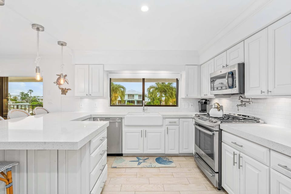 Bright white kitchen with water views and everything you need to cook, snack and hang out.
