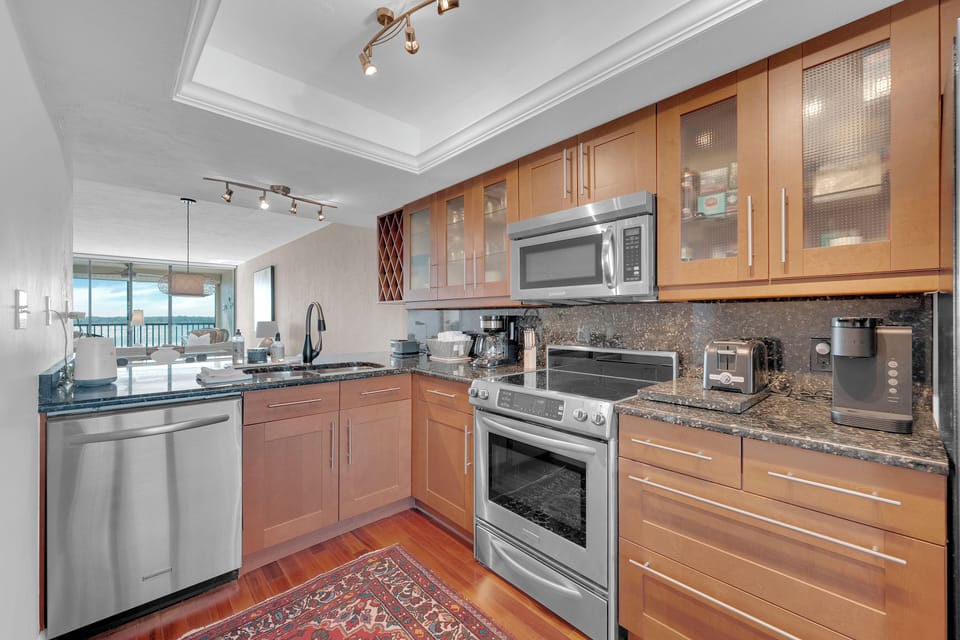 Modern beachfront kitchen with granite countertops, stainless steel appliances, and open-concept layout at Islands End 202, Fort Myers Beach