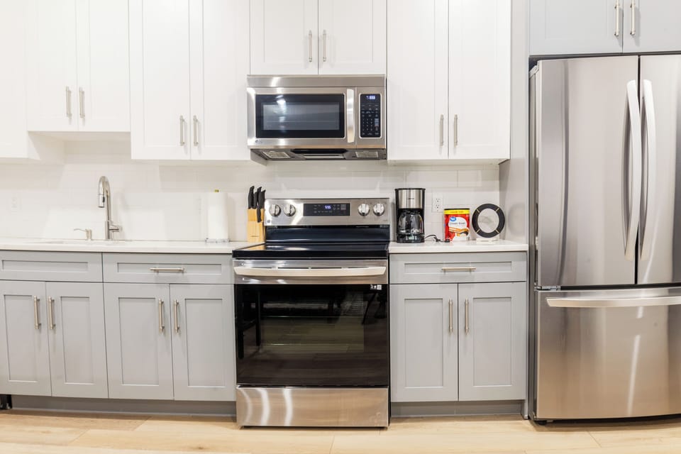 Fully equipped kitchen with a stove, fridge, microwave, coffee maker, and all the essentials for cooking and dining.

