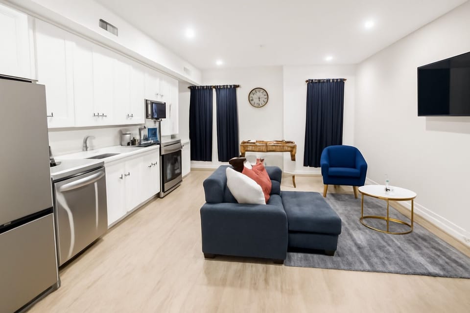 Unwind after a long day of exploring in this bright, modern living room comfy seating, smart TV, and warm lighting create the perfect chill spot.