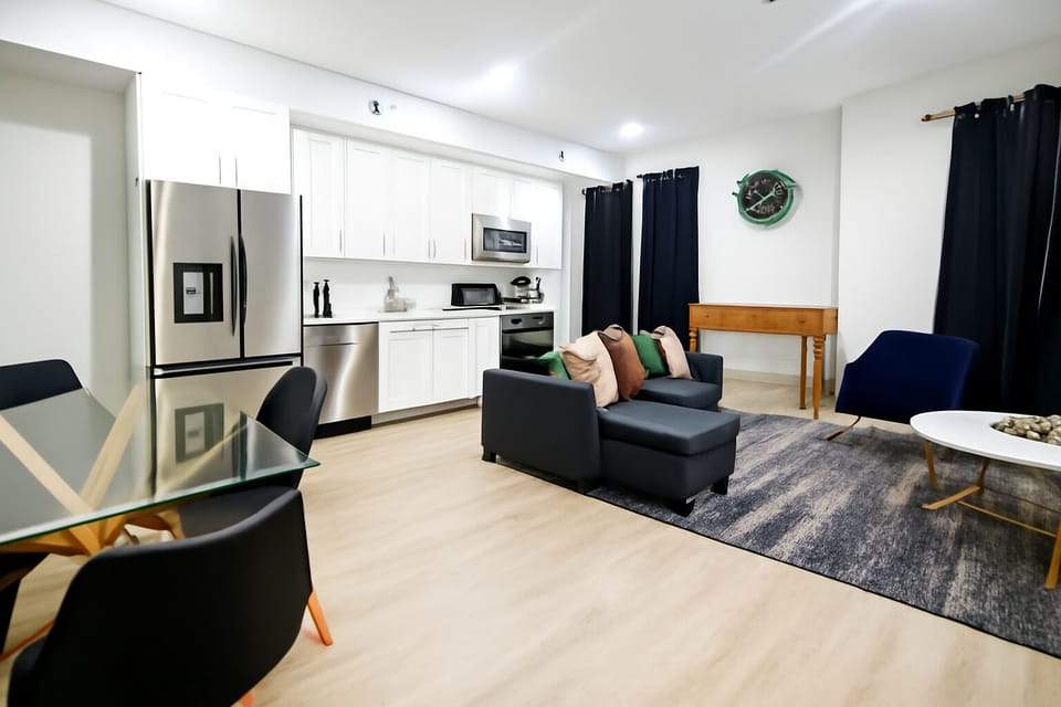 Unwind after a long day of exploring in this bright, modern living room comfy seating, smart TV, and warm lighting create the perfect chill spot.