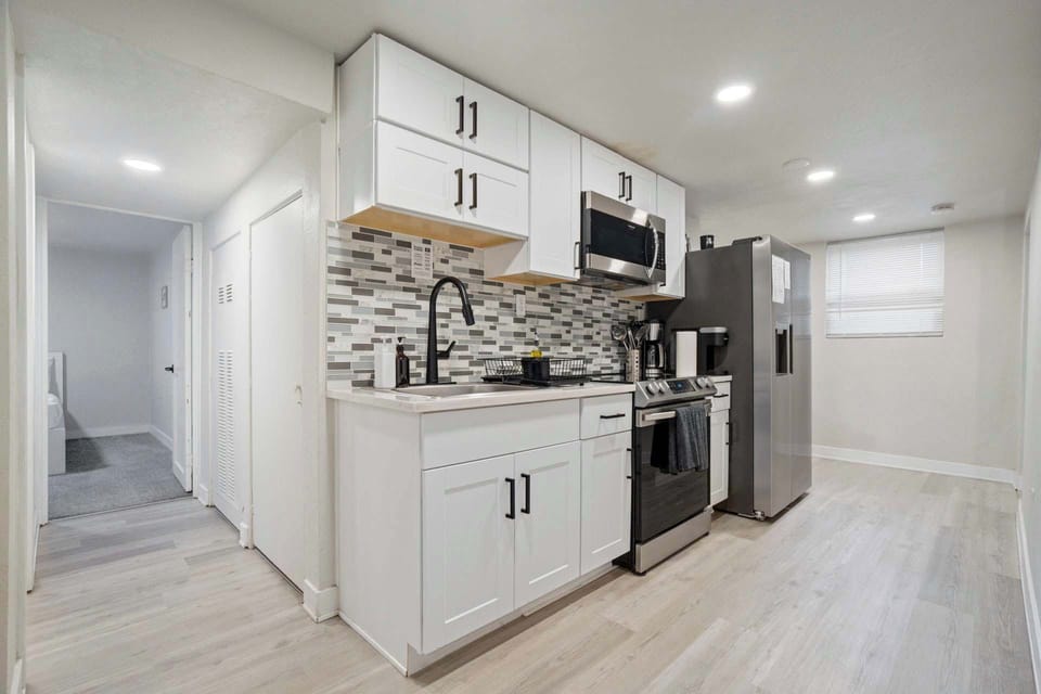 Cook and snack with ease in this crisp kitchen, featuring stainless appliances and a bright, open layout.