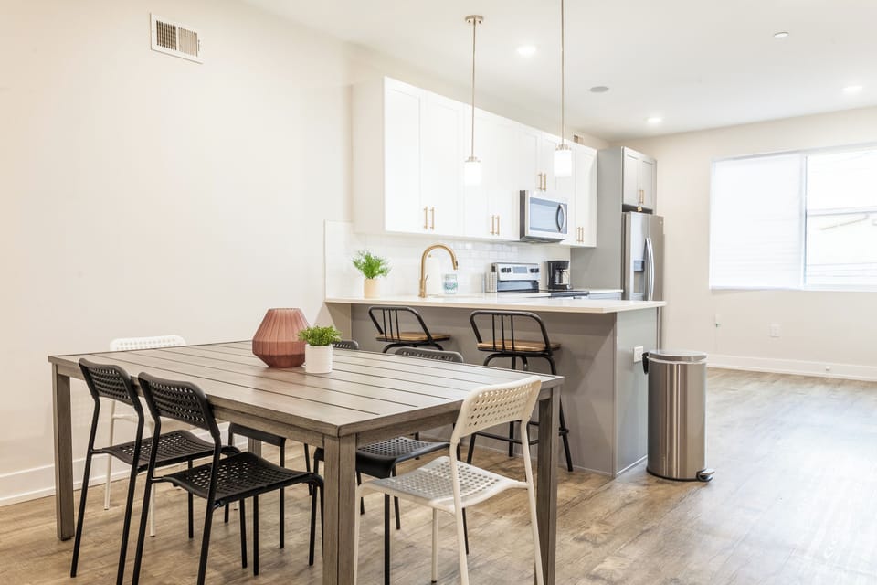 Our open-concept dining area seamlessly blends with the living space, creating a perfect setting for shared meals and conversations. The modern dining set offers both style and comfort. #SocialGathering #MemorableMeals 