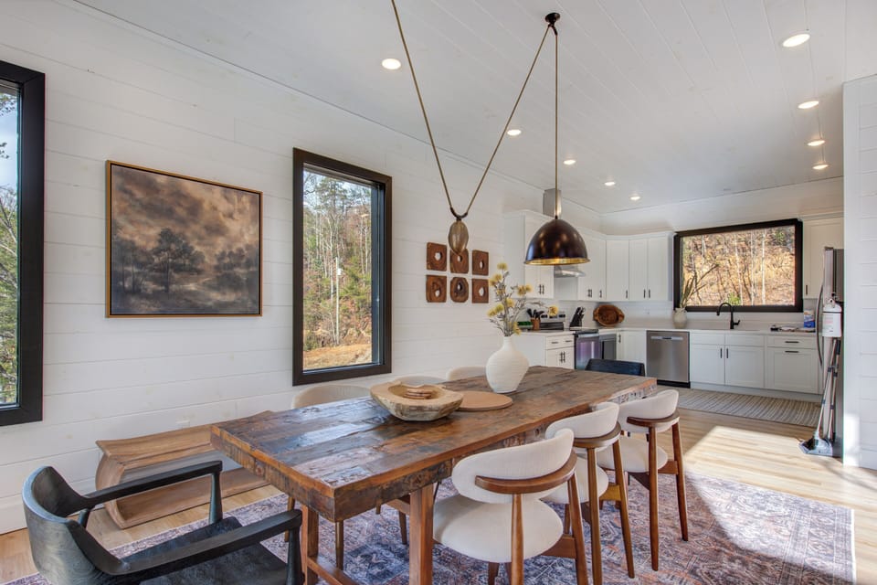 Gather around your rustic dining table where warm wood meets modern elegance, with natural light streaming through windows.