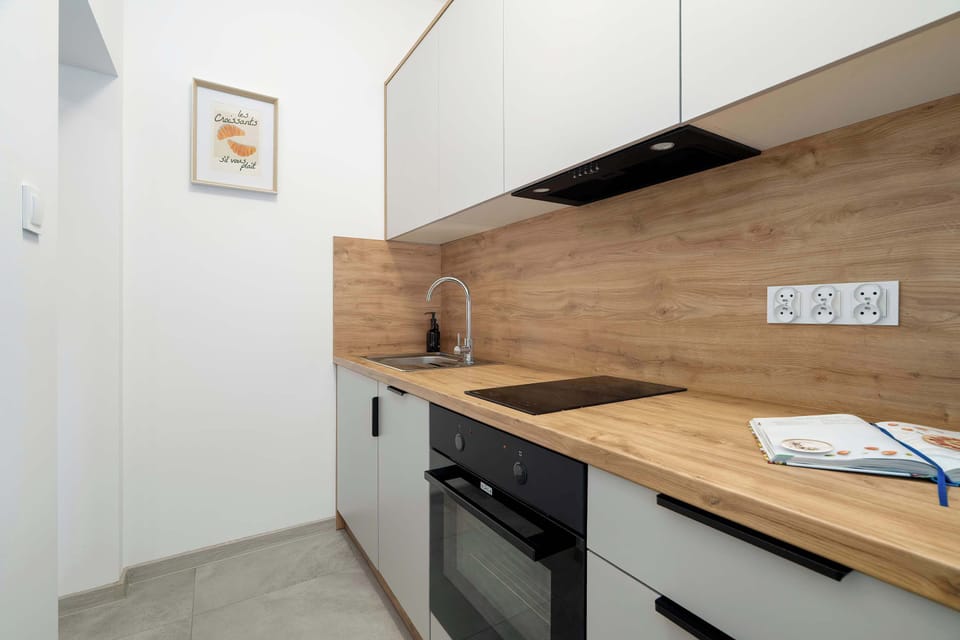 A view of the kitchen with a wooden countertop and modern appliances invites you to cook together and enjoy your meals.