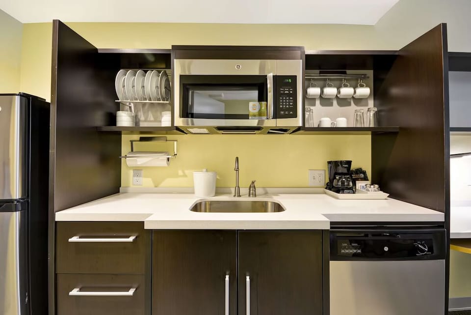 Enjoy easy meals with microwave, sink, and neatly stocked shelves.