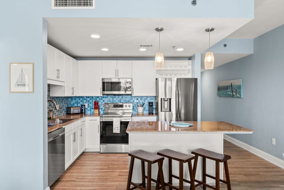 Bright and modern kitchen featuring stainless-steel appliances and sleek white cabinetry.