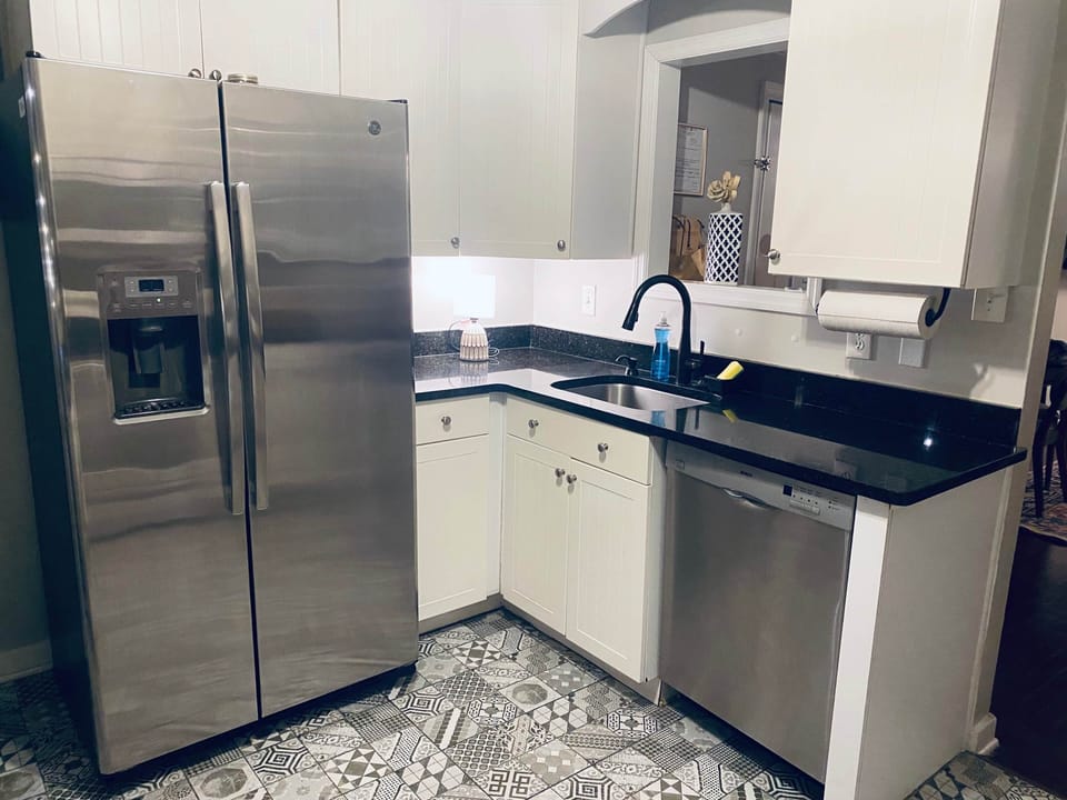 Modern kitchen with stainless steel appliances and sleek black countertops.