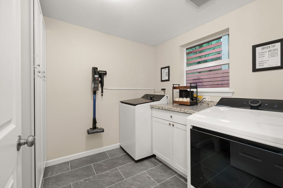 Utility Room – Washer, dryer, drying rack, broom, iron, vacuum, soap