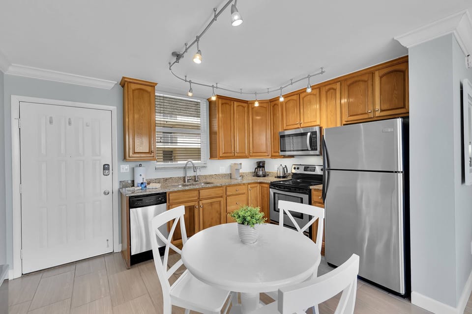 A dining table with seating for four is in the well-equipped kitchen.