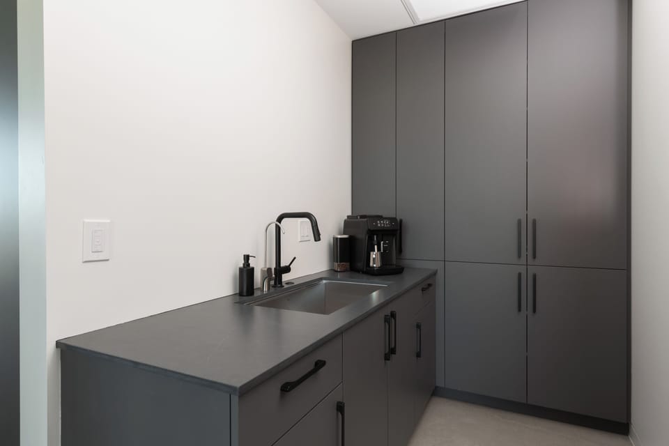 Butler pantry has a second sink and automatic espresso machine.