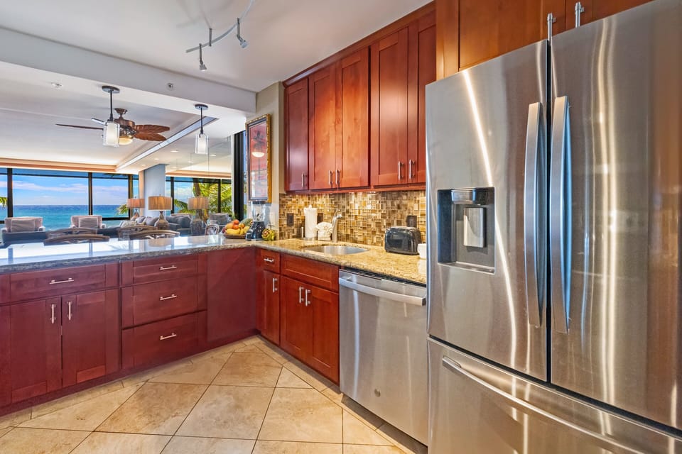 Kitchen with wooden cabinetry, stainless steel appliances, and polished countertops.