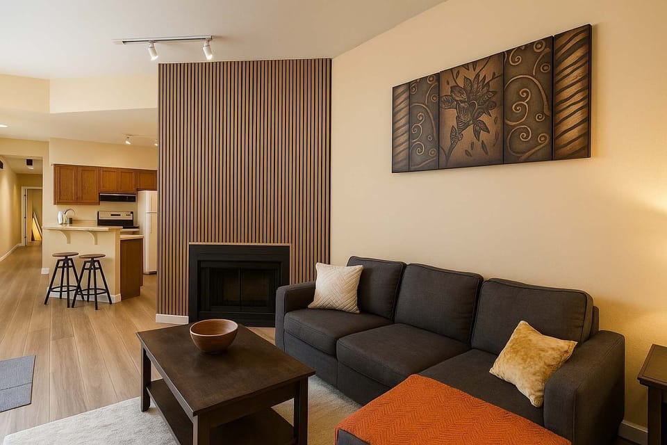 Living room with warm wood accents and a clear sightline to the kitchen and breakfast bar.