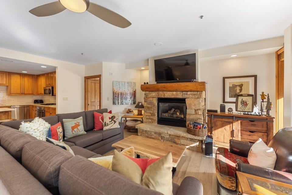 Gather around your cozy stone fireplace with comfortable seating for everyone. The open layout connects you to the fully equipped kitchen.
