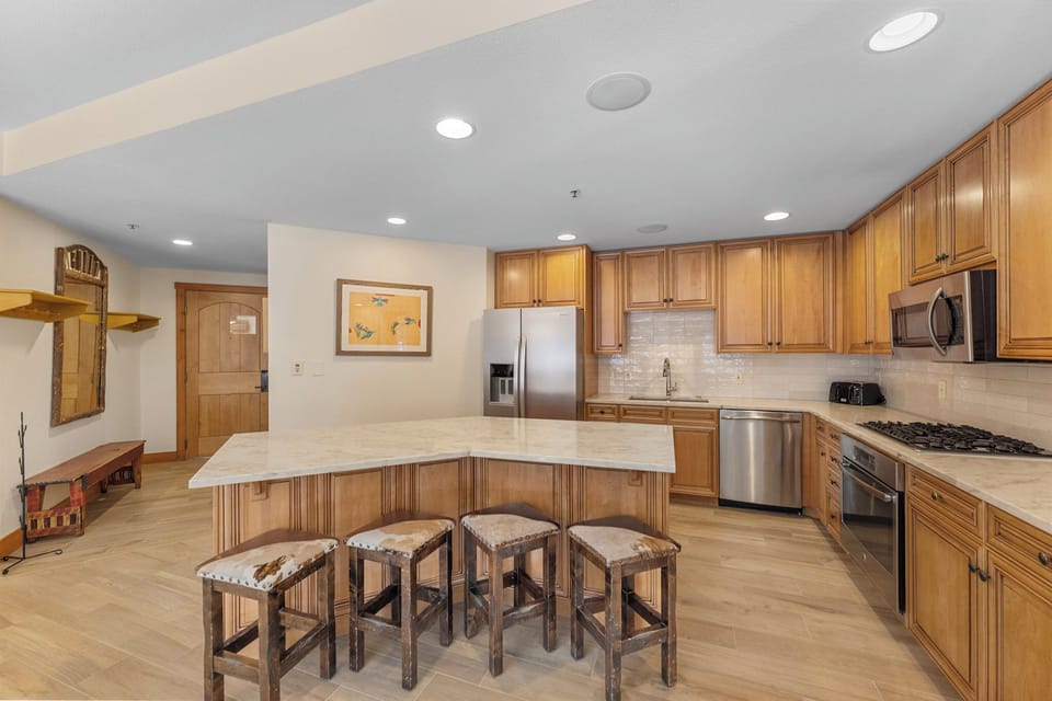 Your gourmet kitchen awaits with warm wood cabinetry, granite counters, and a spacious island where you'll gather for morning coffee and evening conversations.