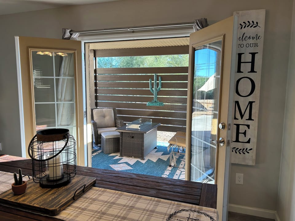 French doors off the kitchen lead to the outdoor shaded pergola with fire table.