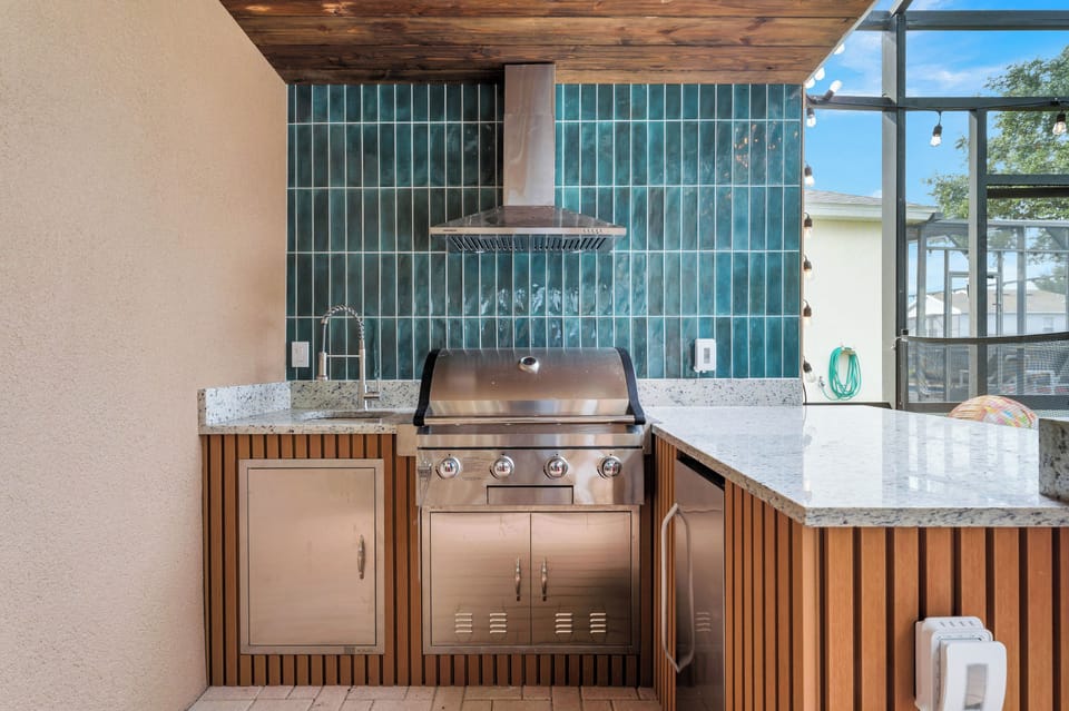 Summer Kitchen: A built-in grill and sleek teal tile backsplash make outdoor cooking a breeze!
