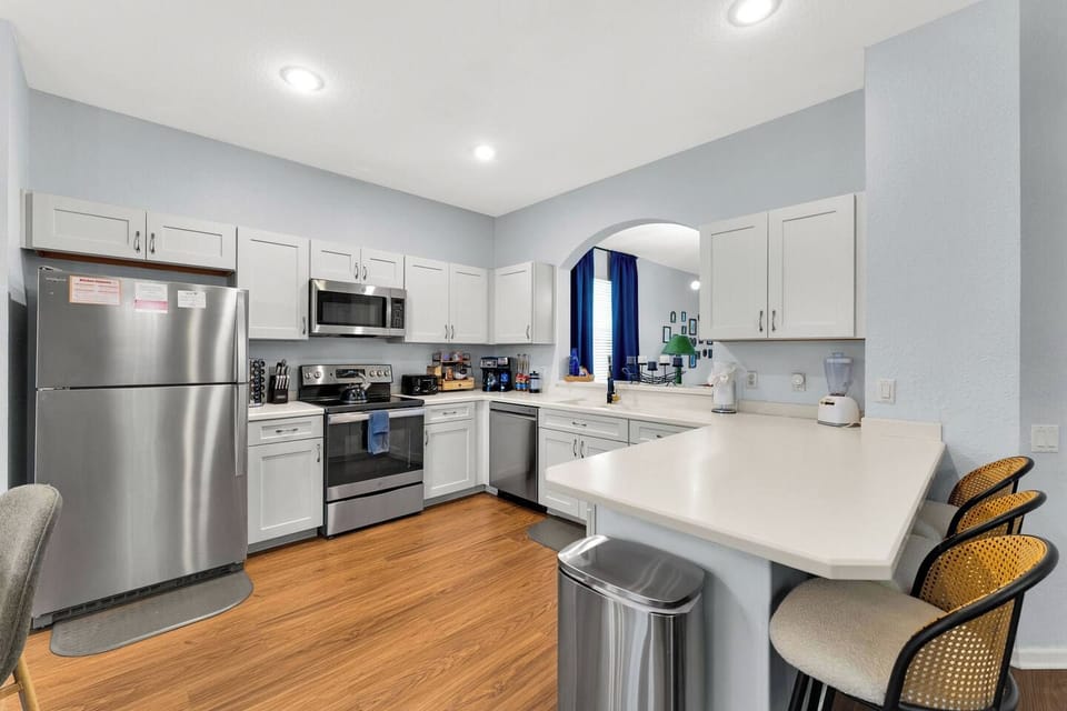 Full Kitchen: Crisp white cabinetry, stainless steel appliances, and a breakfast bar with stool seating!